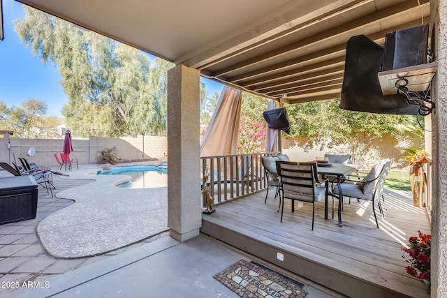 wooden terrace with a fenced in pool and a patio