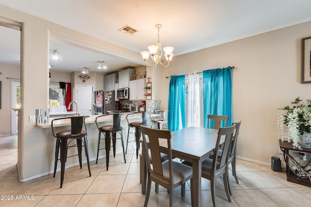 dining space with light tile patterned flooring and a notable chandelier