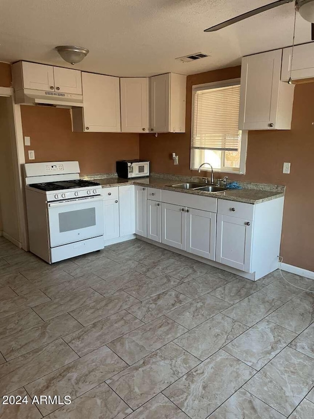 kitchen with white range with gas cooktop, white cabinetry, sink, and a textured ceiling