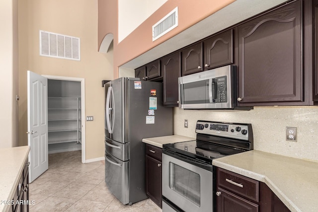 kitchen with dark brown cabinets, visible vents, appliances with stainless steel finishes, and light countertops