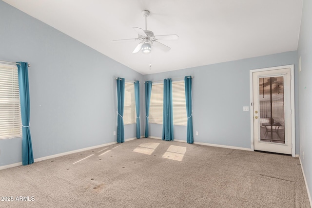 carpeted spare room featuring baseboards, a ceiling fan, and vaulted ceiling