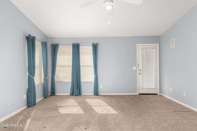 spare room featuring baseboards, ceiling fan, carpet flooring, and vaulted ceiling