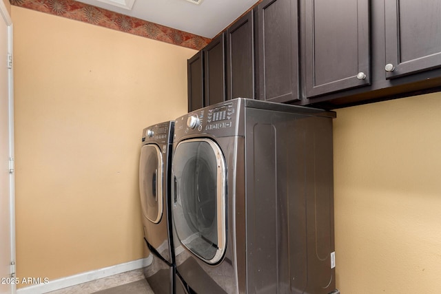 laundry room featuring cabinet space, baseboards, and washer and clothes dryer