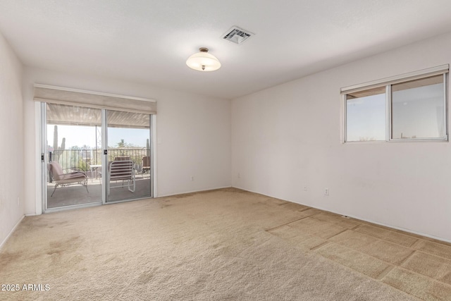 spare room featuring visible vents and carpet flooring