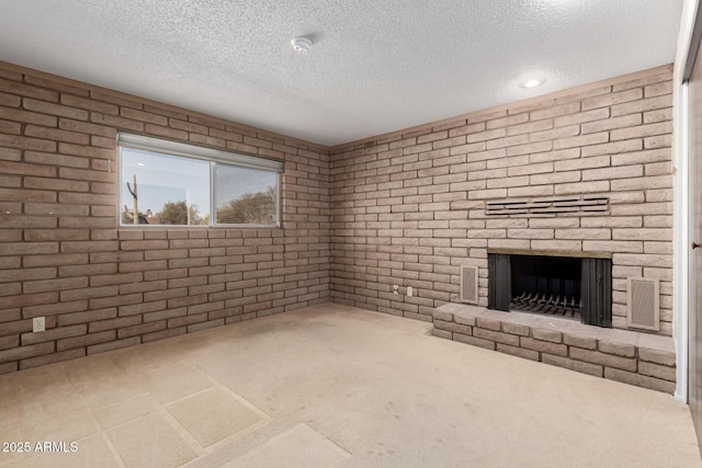 unfurnished living room featuring a fireplace, visible vents, and a textured ceiling