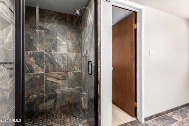 full bathroom featuring a shower stall and baseboards