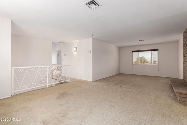 spare room featuring light carpet and visible vents