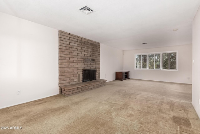 unfurnished living room with carpet floors, a brick fireplace, and visible vents