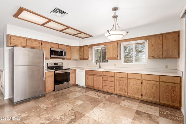 kitchen with light countertops, appliances with stainless steel finishes, hanging light fixtures, and visible vents