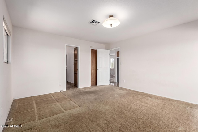 unfurnished bedroom featuring carpet floors and visible vents