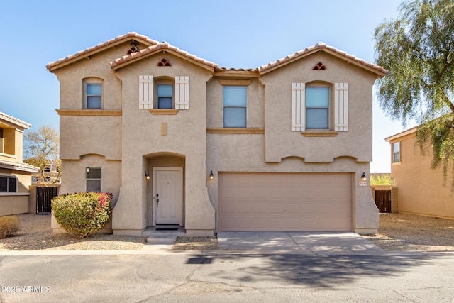 view of front facade with a garage, concrete driveway, a tiled roof, and stucco siding