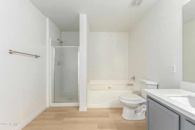 bathroom featuring a stall shower, visible vents, wood finished floors, a garden tub, and vanity