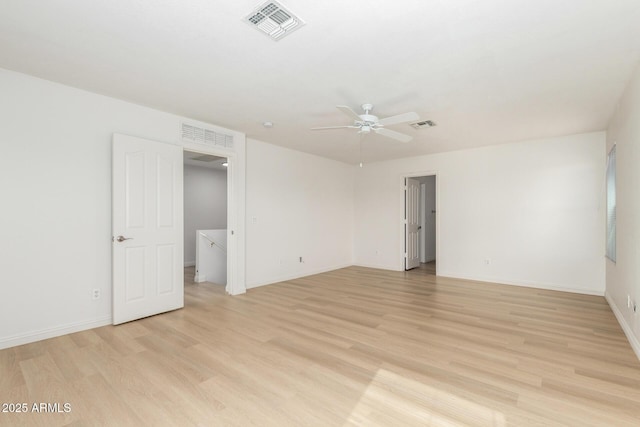 spare room featuring light wood-style flooring, visible vents, and baseboards