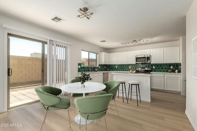 dining area with visible vents and light wood finished floors