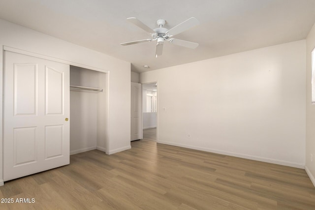 unfurnished bedroom with light wood-style floors, a closet, ceiling fan, and baseboards