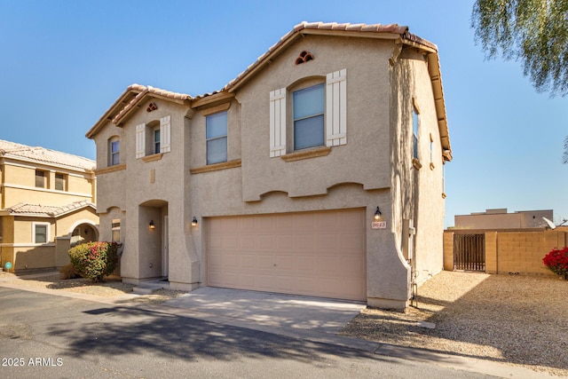 view of front of property with concrete driveway, a tile roof, an attached garage, fence, and stucco siding