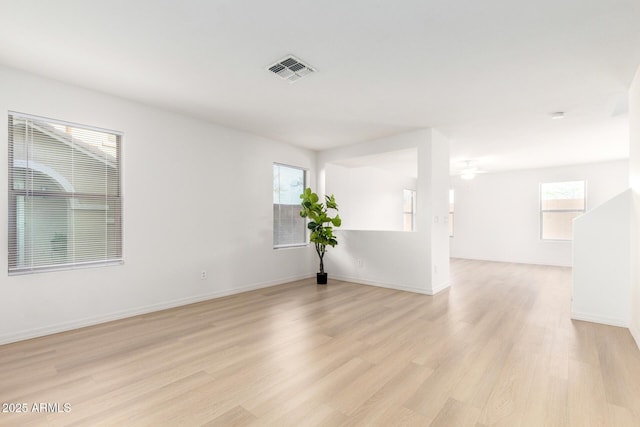 spare room featuring light wood finished floors, baseboards, and visible vents