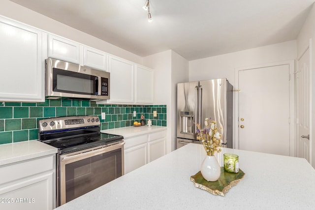 kitchen featuring stainless steel appliances, backsplash, light countertops, and white cabinets