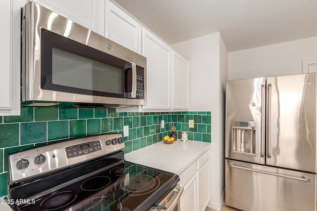 kitchen featuring stainless steel appliances, light countertops, white cabinetry, and decorative backsplash