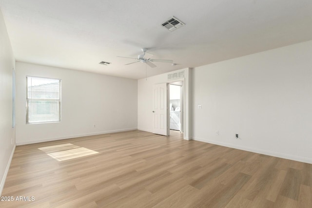 empty room with light wood finished floors, baseboards, visible vents, and ceiling fan