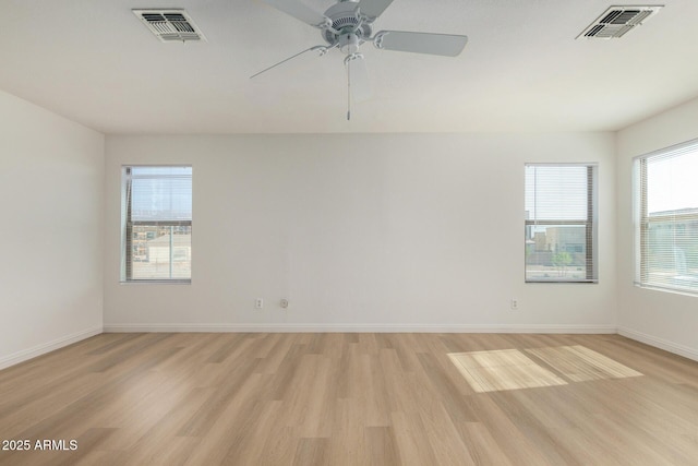 unfurnished room with light wood-style floors, baseboards, and visible vents