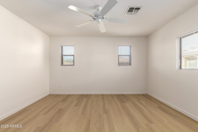 unfurnished room with light wood-style floors, baseboards, visible vents, and a ceiling fan