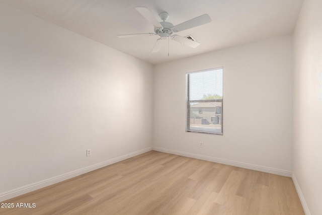 spare room featuring light wood-style flooring, baseboards, and ceiling fan