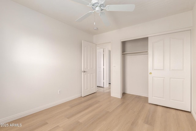 unfurnished bedroom featuring baseboards, a closet, a ceiling fan, and light wood-style floors