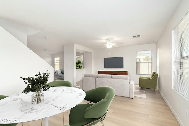 dining space featuring visible vents, ceiling fan, light wood-style flooring, and baseboards