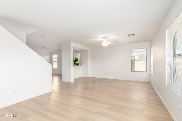 spare room featuring baseboards, visible vents, ceiling fan, and light wood finished floors