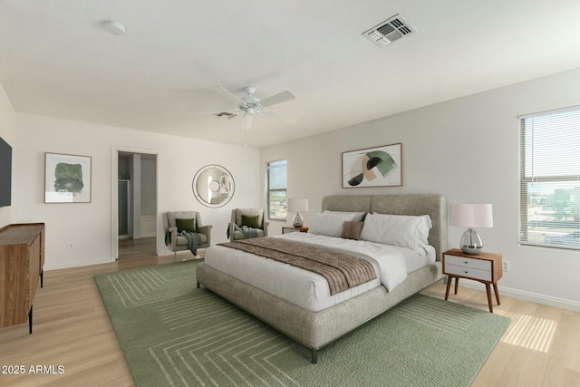 bedroom featuring baseboards, visible vents, light wood finished floors, and multiple windows