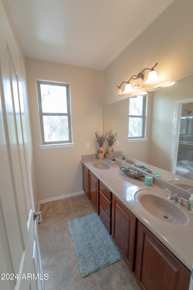 bathroom with a wealth of natural light, tile patterned floors, and vanity