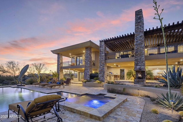 36389 N 105th Pl, Scottsdale, AZ 85262 - back of property at dusk with a balcony, an in-ground hot tub, a patio, an outdoor pool, and stucco siding
