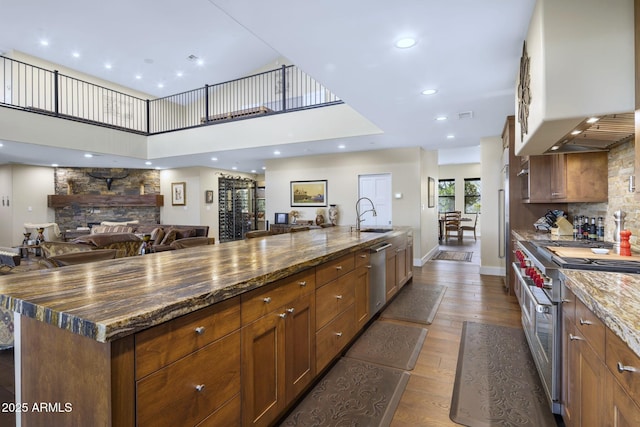 36389 N 105th Pl, Scottsdale, AZ 85262 - kitchen featuring appliances with stainless steel finishes, open floor plan, a sink, dark wood-type flooring, and dark stone countertops