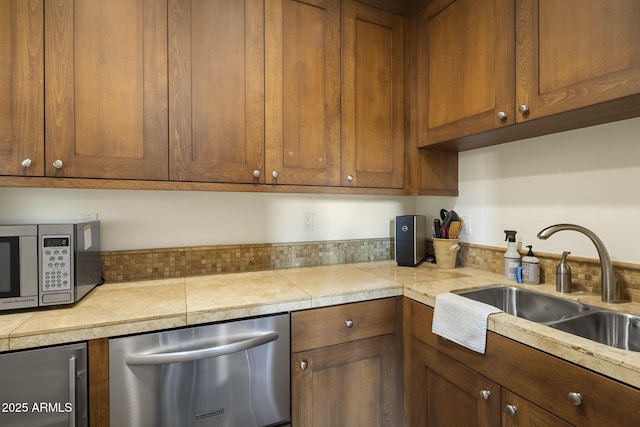 36389 N 105th Pl, Scottsdale, AZ 85262 - kitchen with appliances with stainless steel finishes, a sink, brown cabinetry, and tile counters
