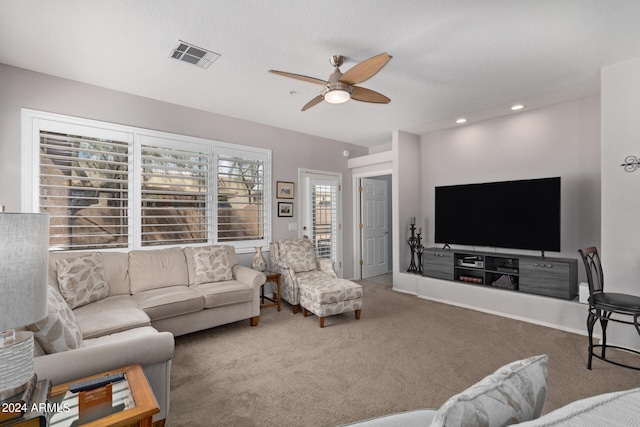 carpeted living room with ceiling fan