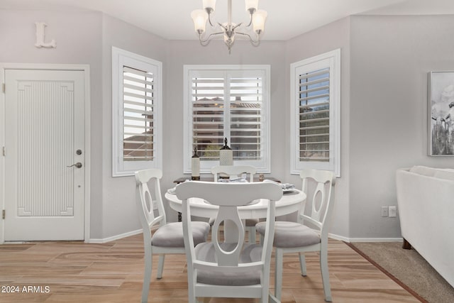 dining space with a chandelier and light hardwood / wood-style flooring