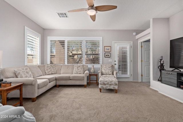 carpeted living room with ceiling fan