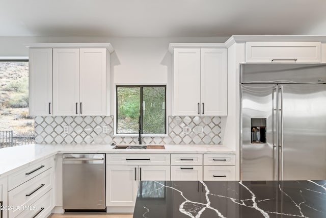 kitchen with sink, stainless steel appliances, and white cabinets