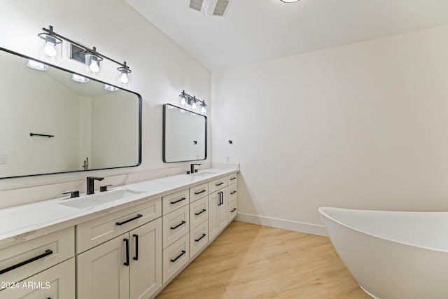 bathroom featuring vanity, a bathtub, and hardwood / wood-style flooring