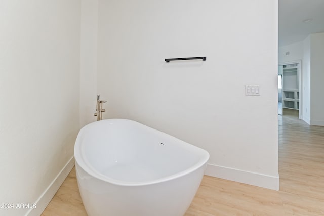 bathroom featuring wood-type flooring and a bathing tub