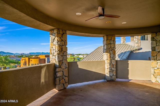 view of patio with a balcony, a mountain view, and ceiling fan