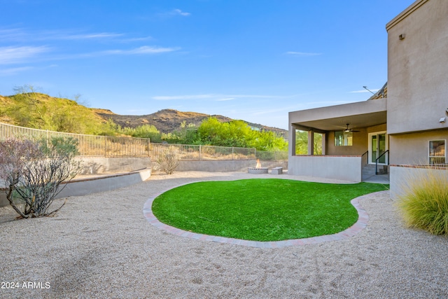 view of yard with ceiling fan, a patio area, and a mountain view