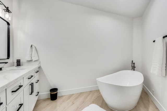 bathroom featuring a tub, hardwood / wood-style floors, and vanity