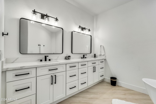 bathroom featuring vanity, hardwood / wood-style floors, and a bathtub