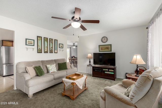 living area with light carpet, a textured ceiling, a healthy amount of sunlight, and a ceiling fan