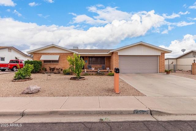 ranch-style home featuring concrete driveway, a garage, fence, and brick siding