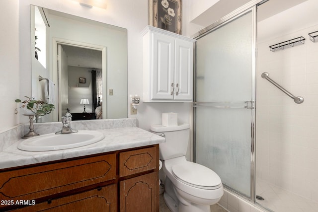 ensuite bathroom with vanity, a shower stall, toilet, and connected bathroom