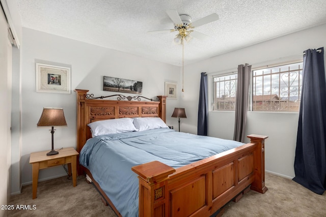 bedroom with light colored carpet, a textured ceiling, and a ceiling fan