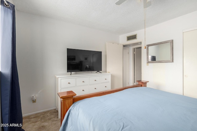 bedroom with a textured ceiling, a ceiling fan, visible vents, and light carpet